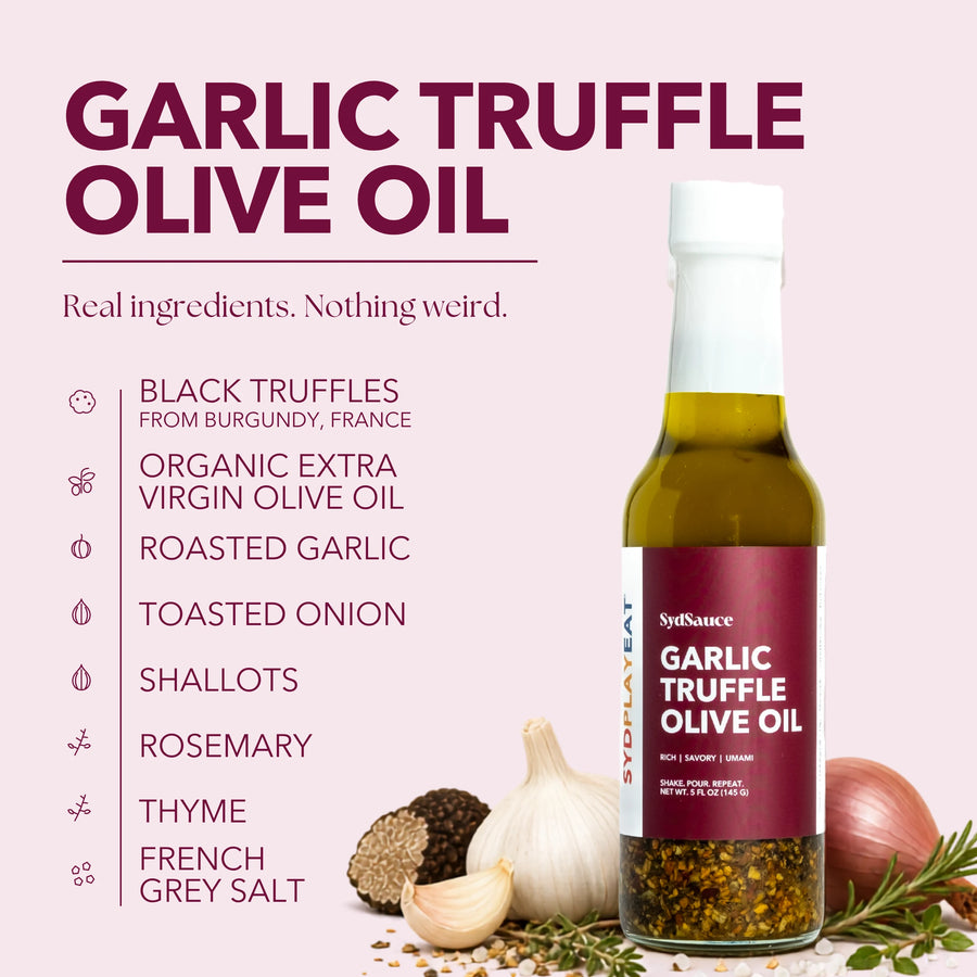 SydSauce Garlic Truffle Olive Oil bottle on a pale pink background with ingredient callouts and food props including garlic, truffle, onion, rosemary, and oil. Large headline reads 'GARLIC TRUFFLE OLIVE OIL'.