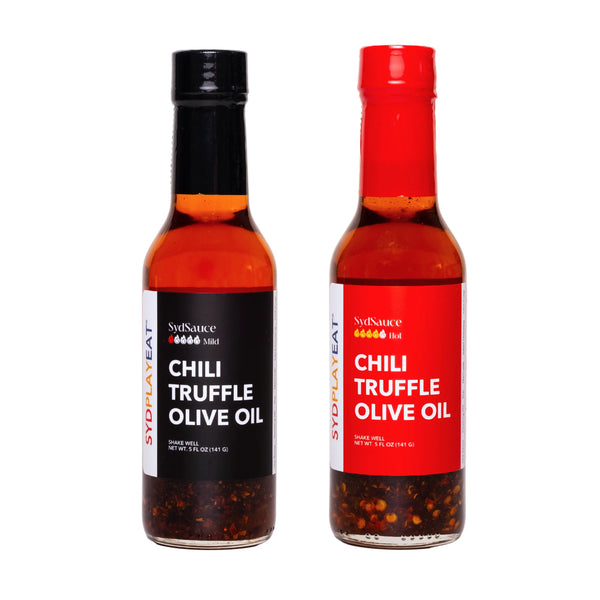 Two glass bottles filled with gourmet chili truffle hot sauce olive oil.