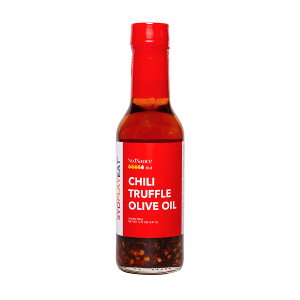 A close-up of chili truffle olive oil hot sauce in a clear bottle.