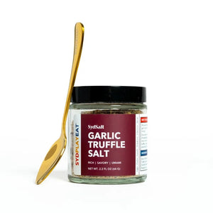 Jar of Sysball Garlic Truffle Salt with a gold spoon on a white background